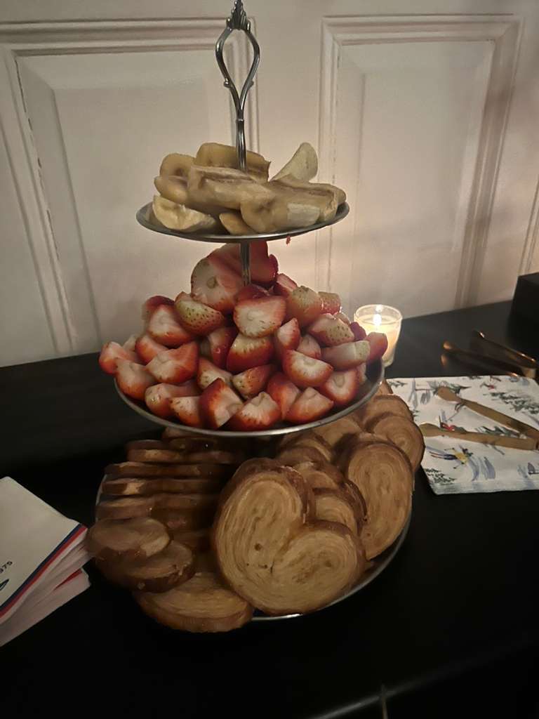 Close-up of the three-tier silver tray — palmiers on the bottom, strawberries in the middle, banana slices on top