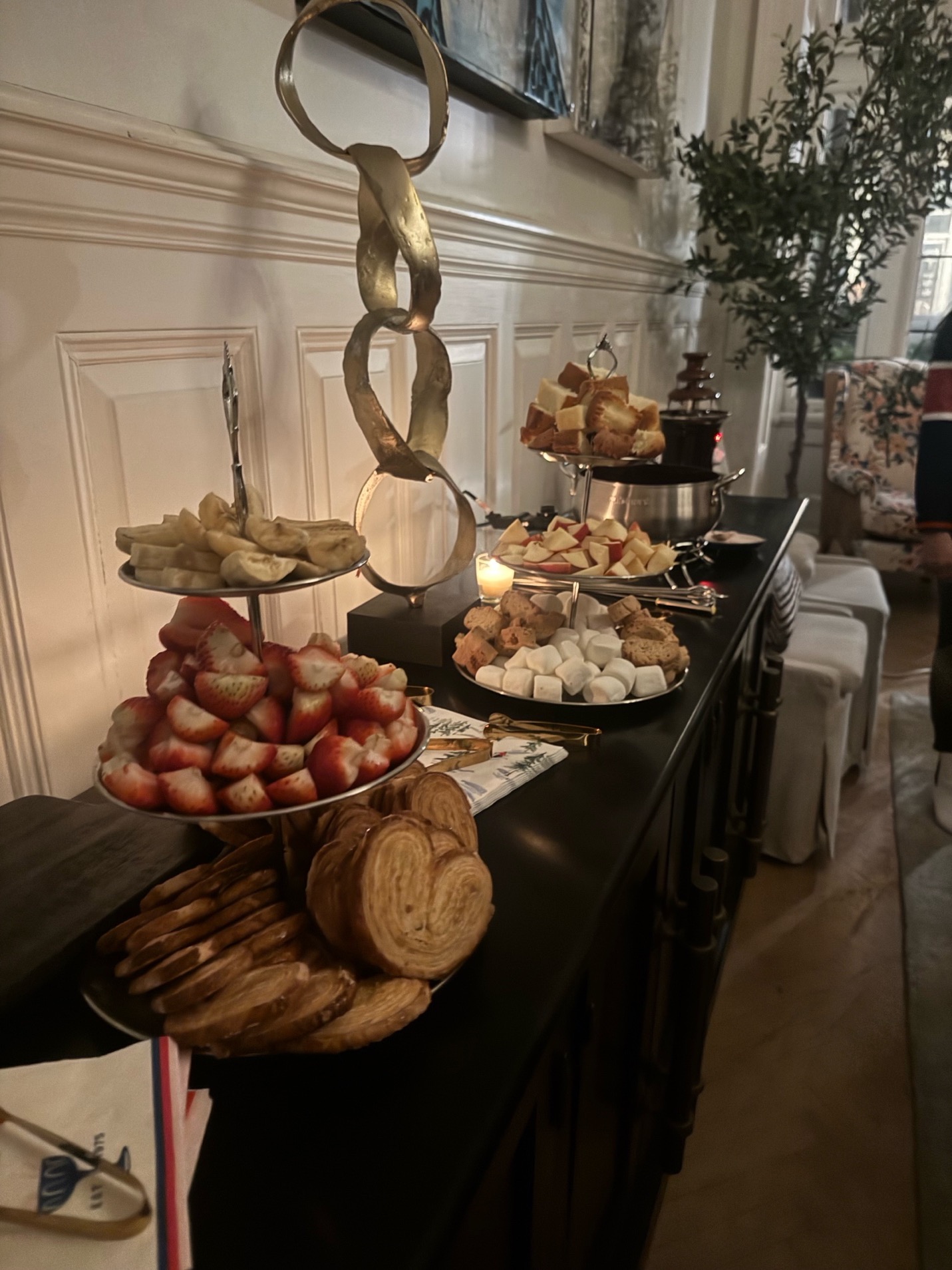Silver tiered trays with palmiers, strawberries, banana slices, and marshmallows for the chocolate fondue course