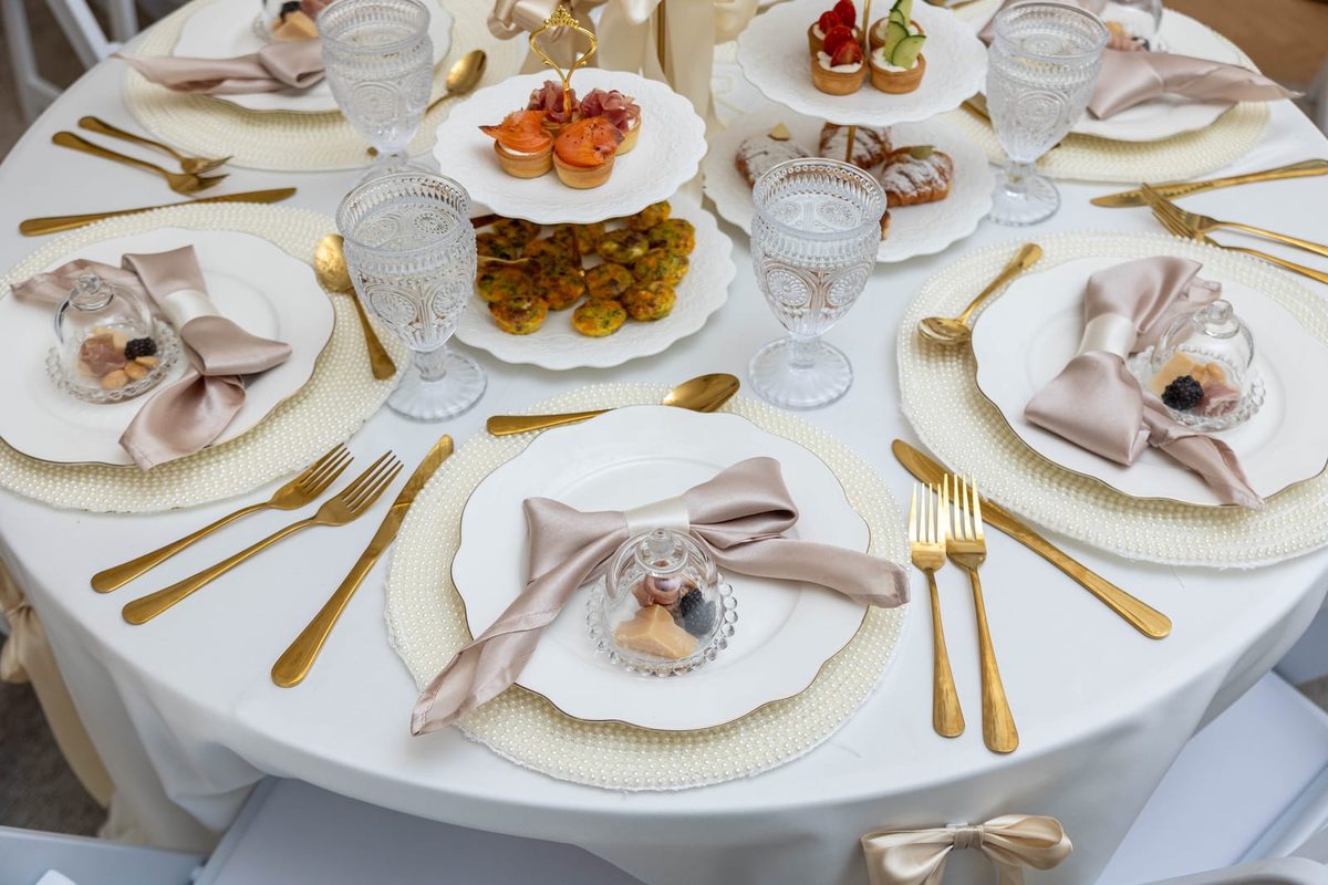 White three-tier tea stands with savory bites at baby shower