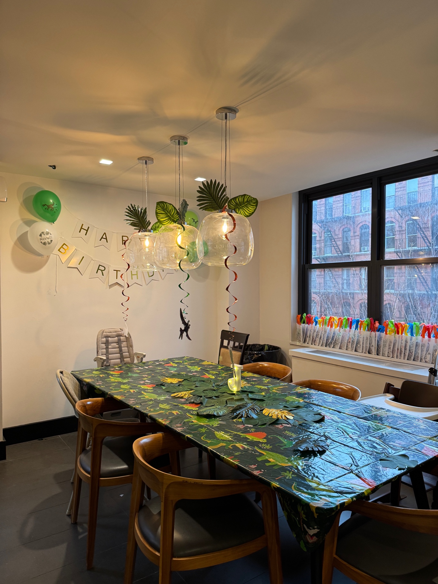 Dining room with dinosaur tablecloth, tropical leaf runner, and spiral streamers