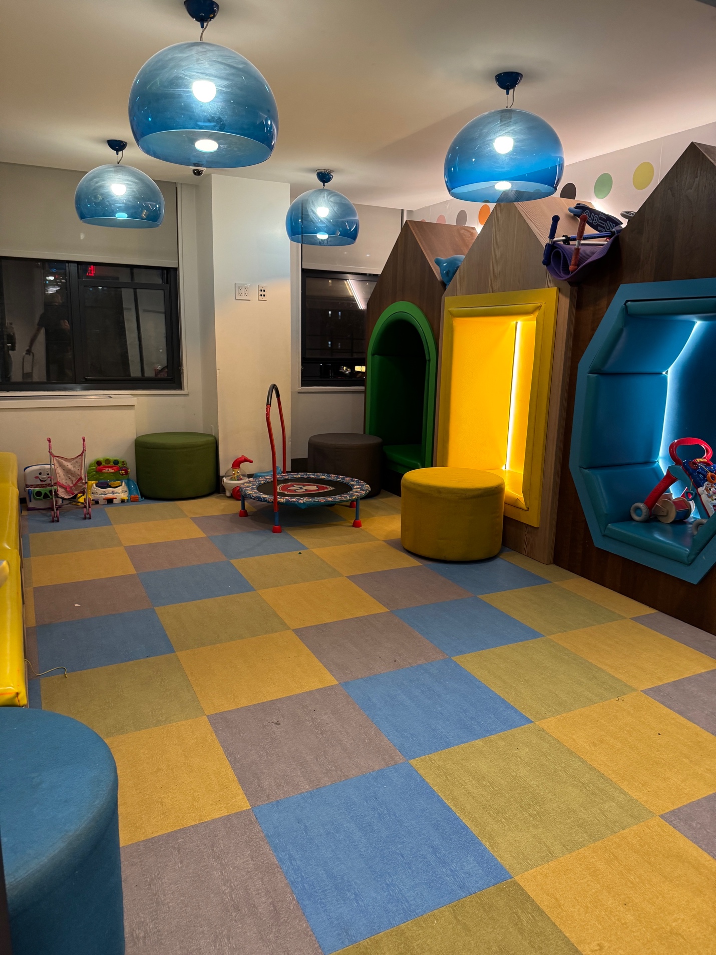 Building playroom with colorful padded floors, built-in castle, and mini trampoline