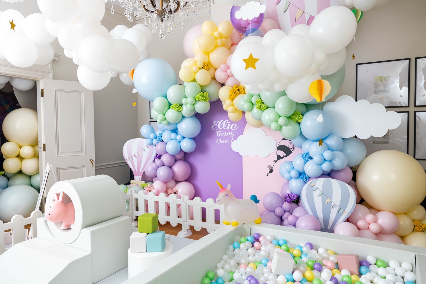 A pastel balloon installation with ball pit and soft play area at a private venue birthday party